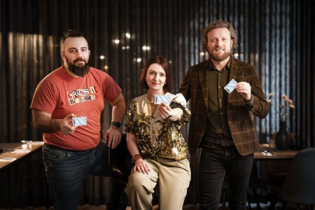 Trzy osoby trzymające w&nbsp;rękach kartę Rybka