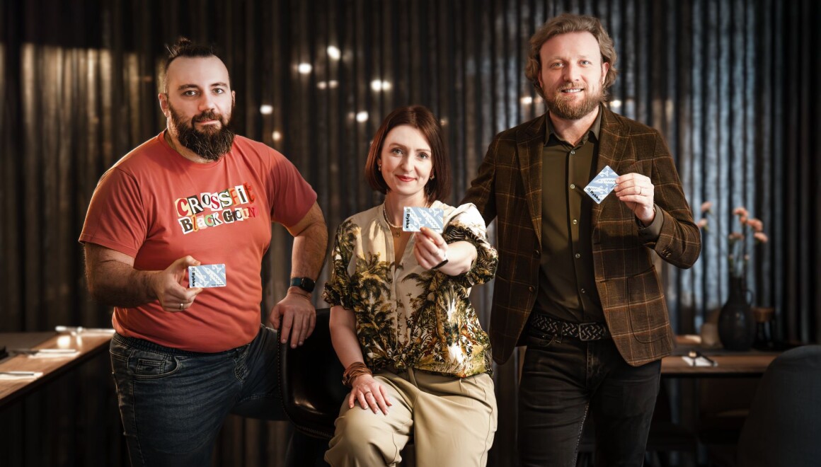 Trzy osoby trzymające w&nbsp;rękach kartę Rybka